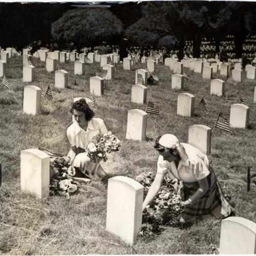 [Thelma Newnham and Dale Parker decorating graves of the honored dead in the National Cemetery]