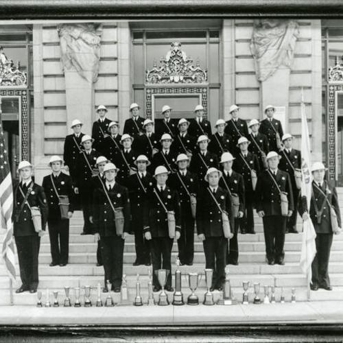 [Loyd holding the S.F.F.D. flag and members of San Francisco Drill Team on steps of City Hall]