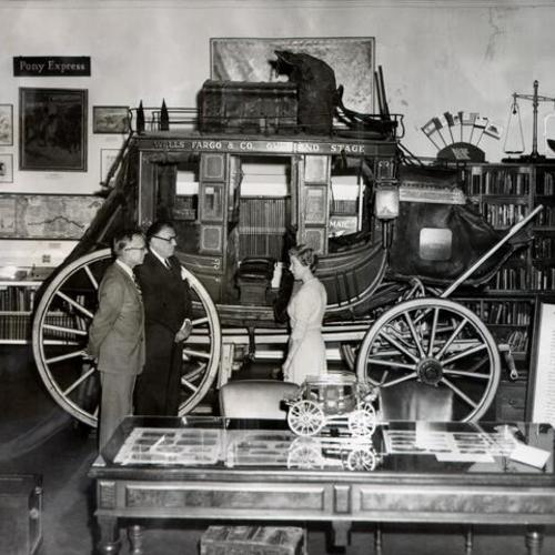 [Thomas Townsend, John D. Boden and Irene Simpson standing in front of a Wells Fargo stagecoach]
