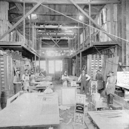 [Workers posing for a picture inside the temporary building of the California Art Glass Works at 938 Howard Street]