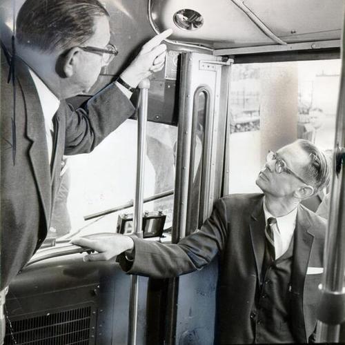 [Stewart N. Greenburg and Rev. Francis Geddes inspecting newly installed safety mirrors on a Muni bus]