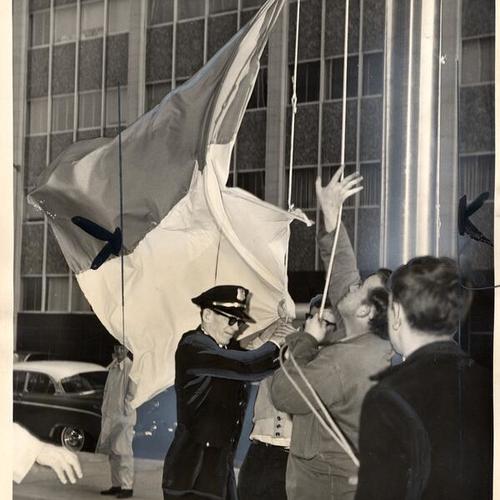 [A GSA policeman trying to keep demonstrators from North Vietnam flag in front of the new Federal building]