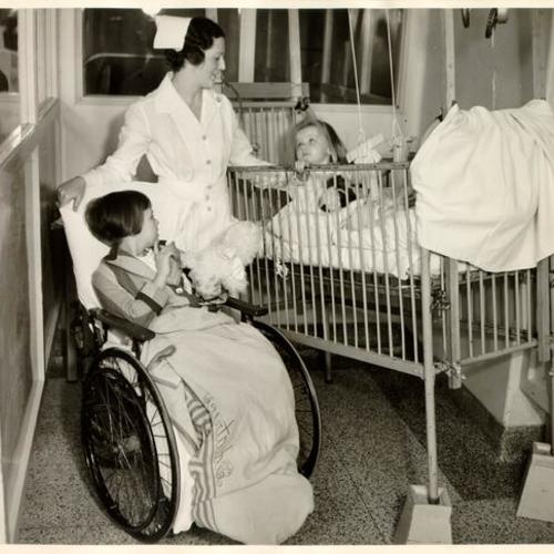 [Nurse Mary McCormick with two young patients at St. Mary's Hospital]
