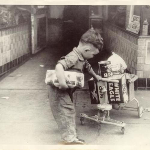 [Boy using his play car to hoard away grocery during general strike in 1934]
