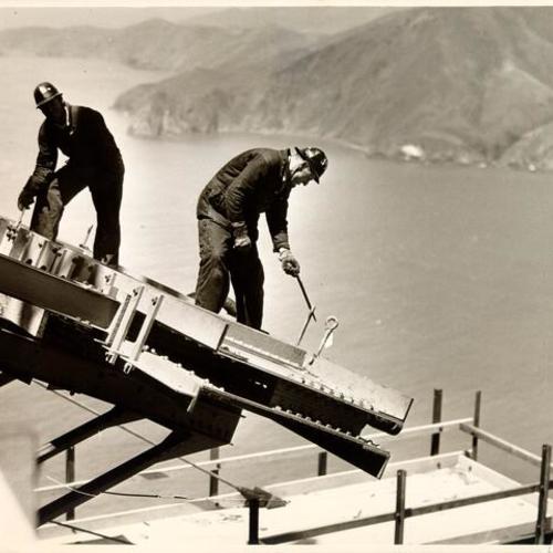 [Golden Gate Bridge workers on top of San Francisco tower working on cable saddle sockets]