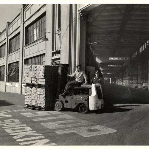 [Civilian worker moving military cargo at a Fort Mason warehouse]
