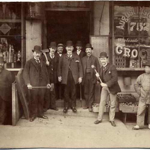 [Chinatown Squad of the San Francisco Police Department posing with sledge hammers and axes in front of August Pistolesi's grocery store at 752 Washington Street]
