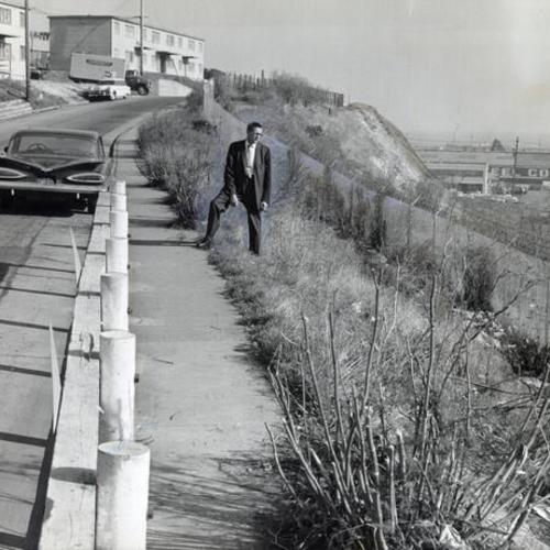 [Joe Allison, The News' "Angry Man," standing next to a steep slope along 26th Street in the Potrero District]