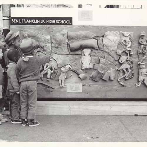 [Children pointing at relief art work belonging to Benjamin Franklin Junior High School]