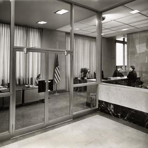 [View of the reception desk and the mural in the foyer of the renovated San Francisco Chamber of Commerce building]