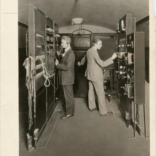 [Two employees operating equipment at the Pacific Telephone & Telegraph Company]