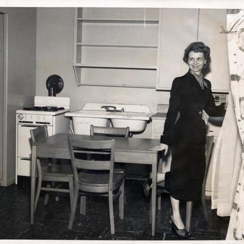 [Loraine May inspecting the kitchen of an apartment in the Francisco Plaza housing project]