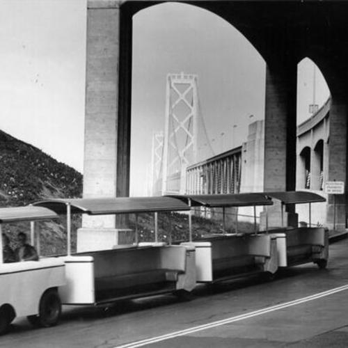 ["Elephant trains," left over from the 1939 Exposition, crossing the Bay Bridge on their way to Golden Gate Park]