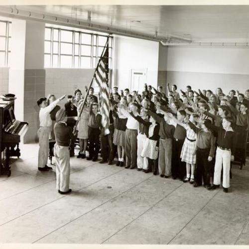 [Students saluting an American flag at Lawton School]
