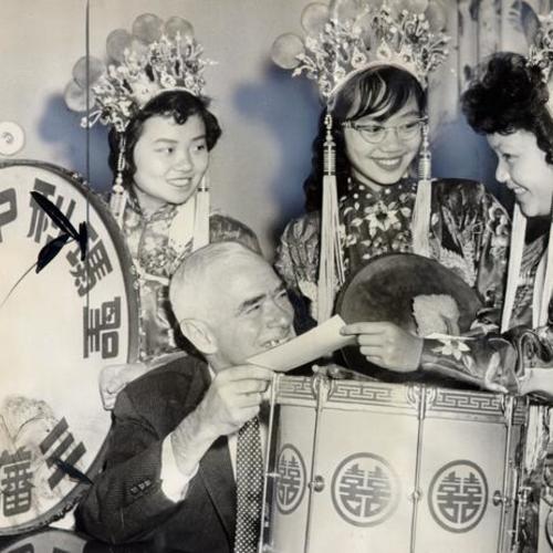 [Grace Lee, Edna Mar and Barbara Quan of the St. Mary's Chinese Girls Drum Corps receiving a donation from Roger Kent]