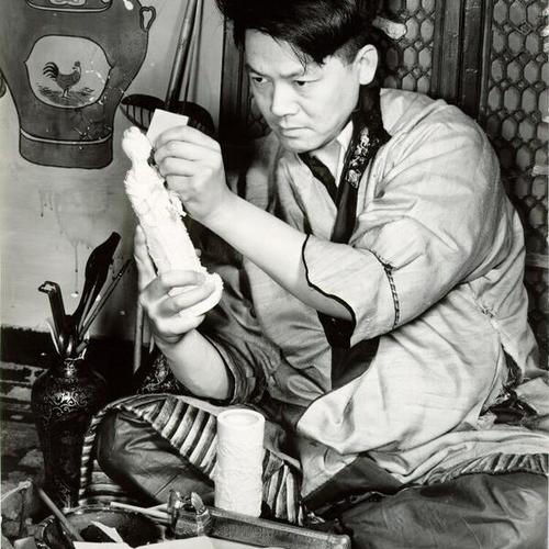 [Unidentified man carving ivory at a shop on Grant Avenue in Chinatown]