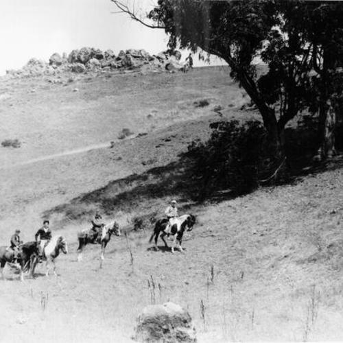 [Four people riding horses in Glen Canyon]