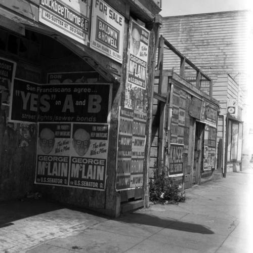 Withered storefront covered with campaign ads