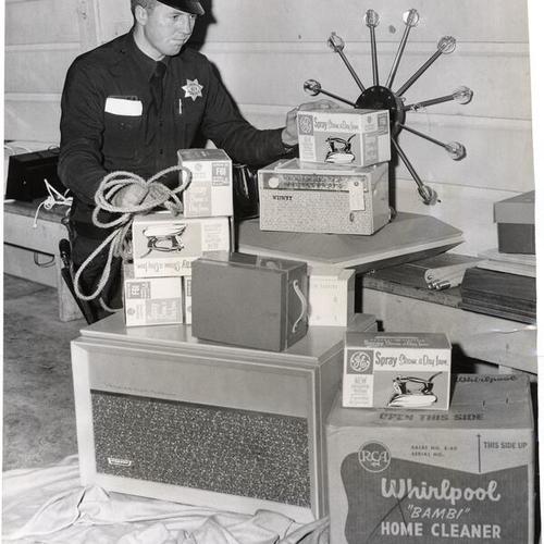 [Police officer Paul McGoran with items stolen from a furniture store]