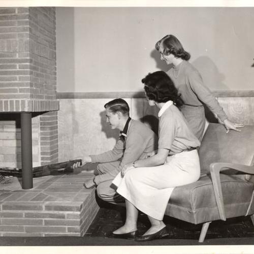[Youth gathering around fireplace at the new Park Presidio Branch of the Metropolitan Y.M.C.A.]