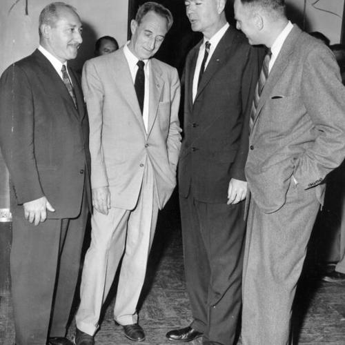 [Defense attorneys confer with Harry Bridges as his deportation trial opens in Federal Judge Louis E. Goodman's court]