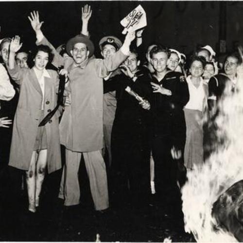 [Crowd celebrating Japanese surrender at end of World War II with bonfire on Market Street]