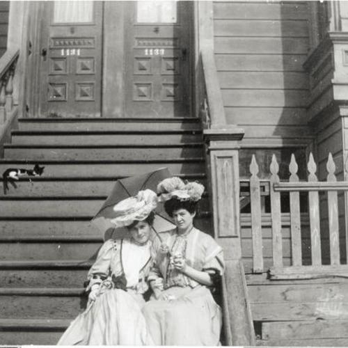 [Portrait of two women sitting on steps of house on Treat Street]
