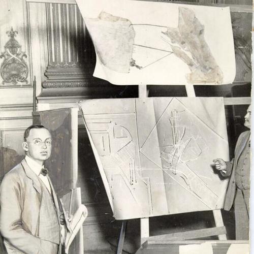 [James McSheehy standing next to some architectural plans]