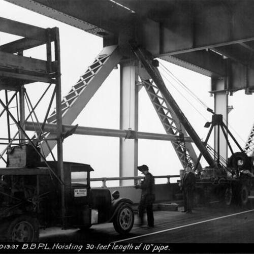 [Employees of W. E. Thomas Welding Company hoist 30 foot length of pipe into place on Bay Bridge]