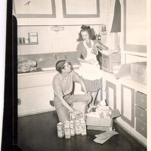 [Man and woman unpacking supplies in a residence on the Farallon Islands]
