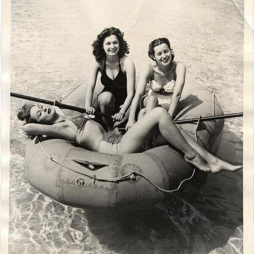 [Swimmers demostrating post war use of the rubber life raft]