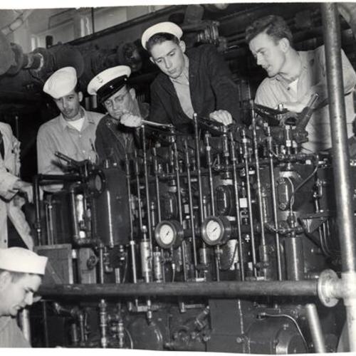 [Naval Reservists from Yerba Buena Island studying a diesel motor at Samuel Gompers School]
