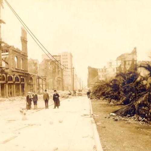 [Four people standing on Post Street, next to Union Square Park, after the earthquake and fire of April, 1906]