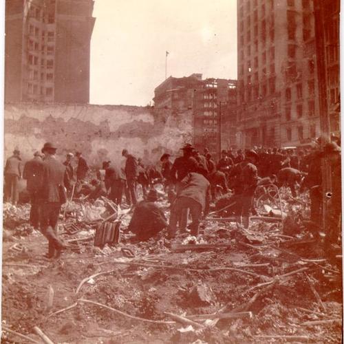 [Crowd scavenging at the site of a jewelery store destroyed in the earthquake and fire]