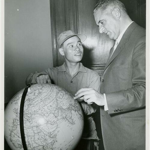 [Mayor Christopher George looking at globe with man]