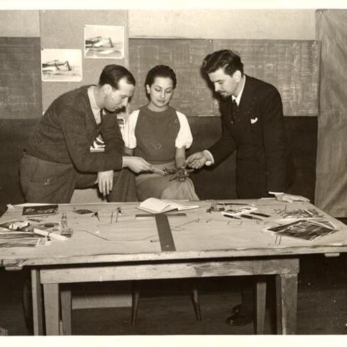 [Artists John Townsley and Irene Palladine showing regional director Joseph Danysh the construction progress on the model of the rebuilt San Francisco airport]