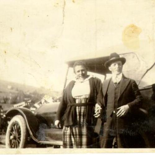 [Woman and man standing next to a car in Visitacion Valley]