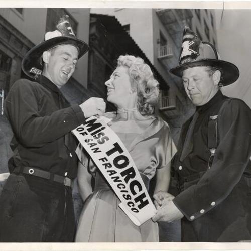 [Firemen Ed Callan and Jack Smith posing with Paulette Goddard, "Miss Torch of San Francisco"]