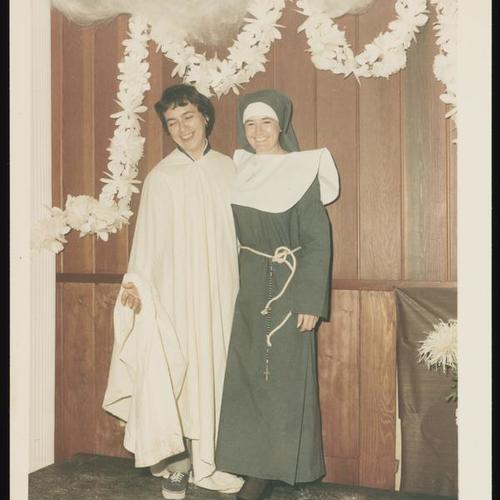 Portrait of two people in priest and nun costumes on stage