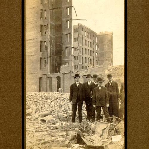 [Several men standing amidst the ruins of the Postal Telegraph]