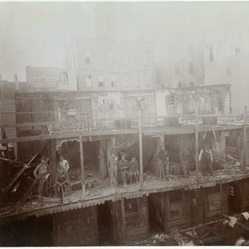 089 People with axes on top of wooden building during demolition