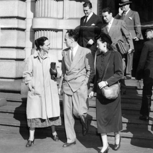 [Harry Bridges leaving court accompanied by his wife and a woman acquaintance followed by his legal staff]