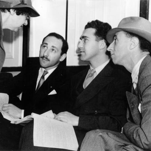 [Harry Bridges and his battery of defense attorneys consult on the day's battle ahead of them as their boat takes them to Angel Island for deportation hearing]