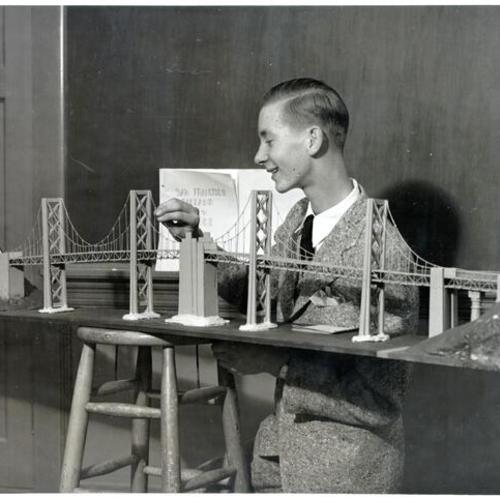 [Junior high school student Ted Pedersen standing next to a model of the West Bay crossing of the San Francisco-Oakland Bay Bridge he made as a school project]