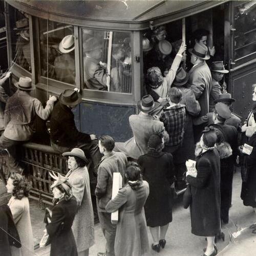 [People trying to board a crowded Market Street Railway streetcar at rush hour]