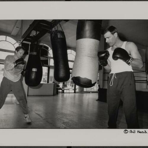 Two boxers hitting heavy bags at Newman's Gym at 124 Leavenworth Street