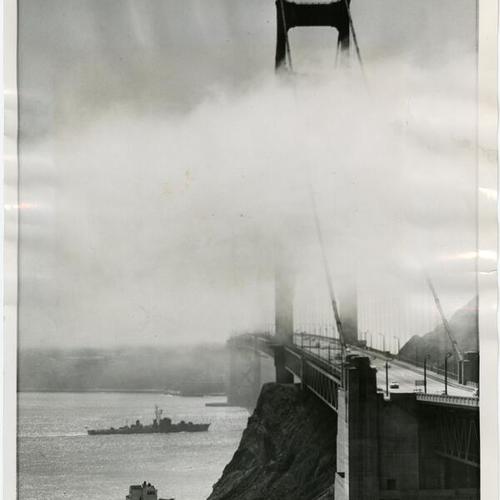 [Japanese ship passing under Golden Gate Bridge as fog enveloping bridge tower]