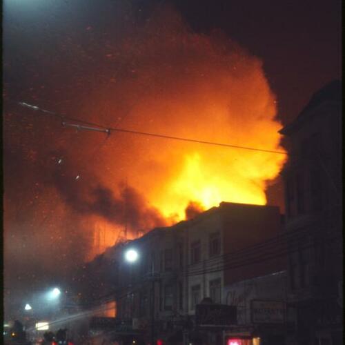 [Street view of firefighters as they battle fire at night on Mission Street]