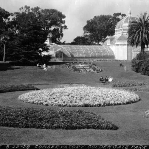 [Conservatory of Flowers in Golden Gate Park with circular flower bed in foreground]