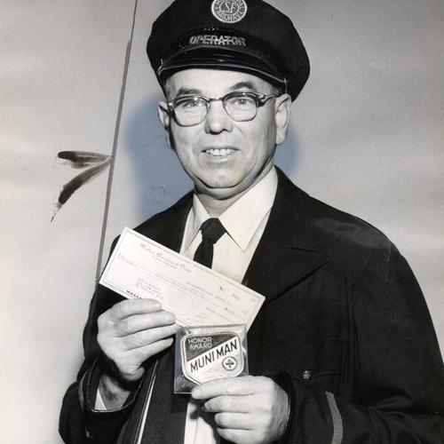 [Muni bus driver John J. McDonagh displaying a check he received as part of a "Muni Man of the Month" award]